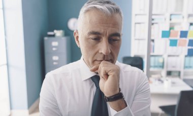 Düşünceli iş adamı çenesi üzerinde düşünüyor: iş çözümleri kavramı