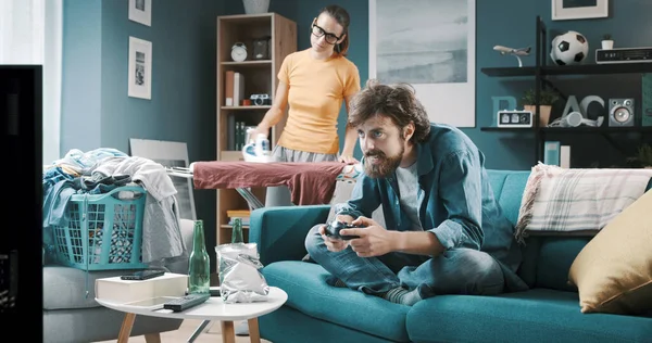 Τεμπέλης Σύζυγος Παίζει Βιντεοπαιχνίδια Και Χαλαρώνει Στον Καναπέ Ενώ Γυναίκα — Φωτογραφία Αρχείου