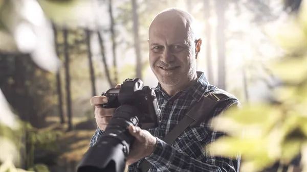 Profesjonalny Fotograf Spacerujący Lesie Kręcący Zdjęcia Uśmiecha Się Kamery — Zdjęcie stockowe