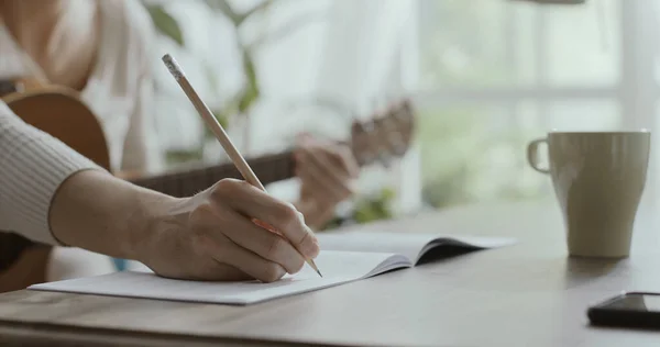 Junge Frau Sitzt Hause Schreibtisch Spielt Gitarre Und Komponiert Musik — Stockfoto