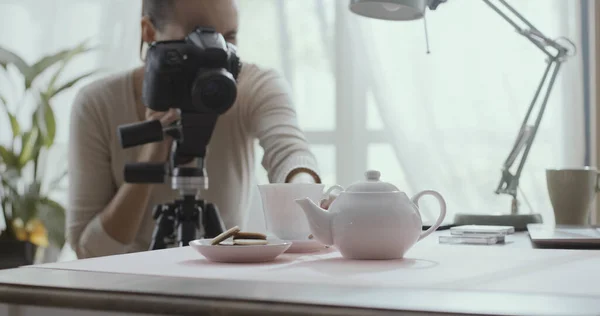 在家里工作的专业摄影师 她正在用茶壶给餐桌布置拍照 — 图库照片