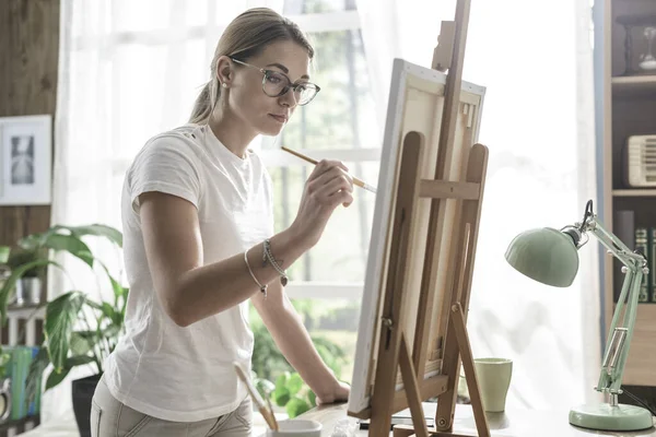 彼女のスタジオでキャンバス上の若い自信の女性の絵画 創造性と趣味のコンセプト — ストック写真