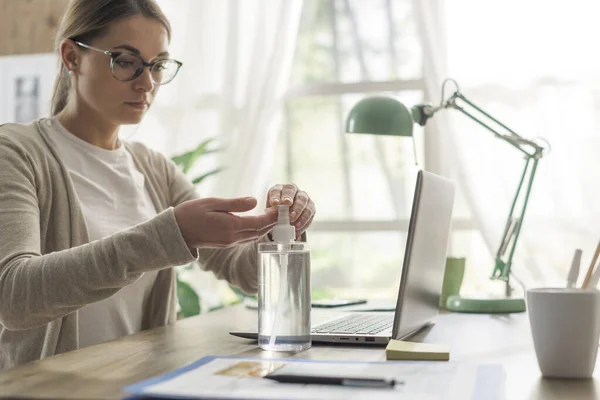 Mujer Joven Sentada Escritorio Aplicando Desinfectante Sus Manos Coronavirus Covid — Foto de Stock