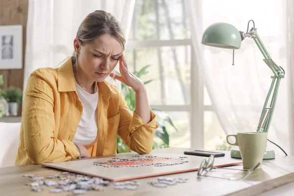 Mujer Joven Resolviendo Rompecabezas Casa Ella Está Teniendo Dolor Cabeza — Foto de Stock