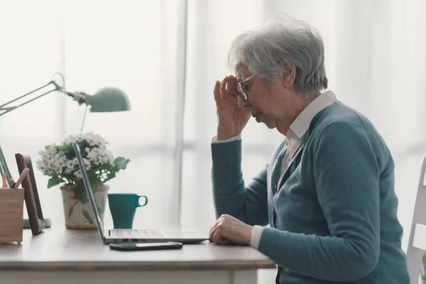 Starsza Kobieta Siedząca Przy Biurku Pracująca Laptopem Silny Ból Głowy — Zdjęcie stockowe