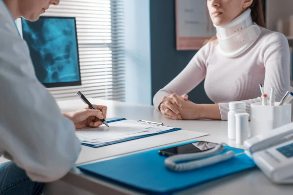 Doktor Masada Oturuyor Boynu Yaralı Bir Hasta Için Reçete Yazıyor — Stok fotoğraf