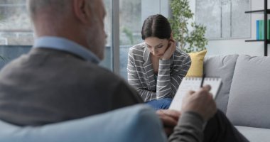 Profesyonel terapist hastasını dinliyor ve notlar yazıyor, psikoterapi ve danışmanlık kavramı.