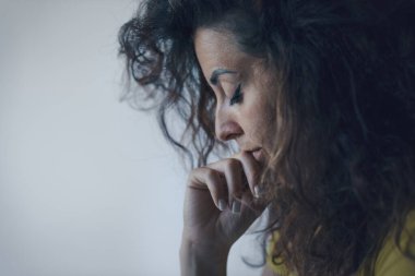 Düşünceli genç bir kadının portresi, elleri çenesinde düşünüyor.