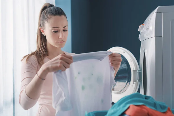 洗濯機の横に立つ失意の女性とステンドグラスの服を保持 — ストック写真
