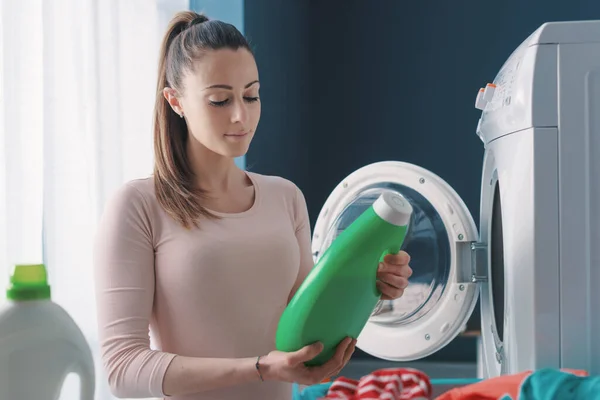 Szczęśliwa Kobieta Robi Pranie Domu Sprawdza Detergent — Zdjęcie stockowe