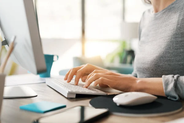 Masada Oturan Çalışan Bir Kadın Bilgisayar Klavyesine Yazı Yazıyor — Stok fotoğraf