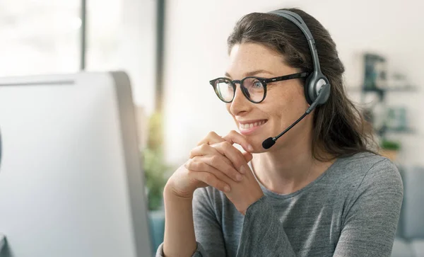 Professionelle Frau Sitzt Schreibtisch Sie Trägt Ein Headset Und Arbeitet — Stockfoto