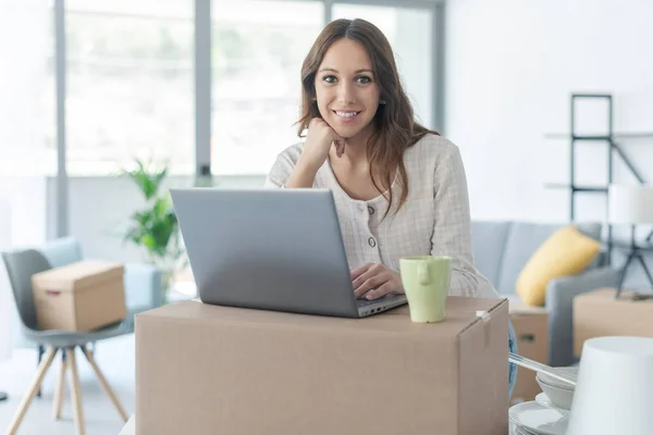 Glimlachende Vrouw Verhuizen Haar Nieuwe Huis Verbonden Met Haar Laptop — Stockfoto