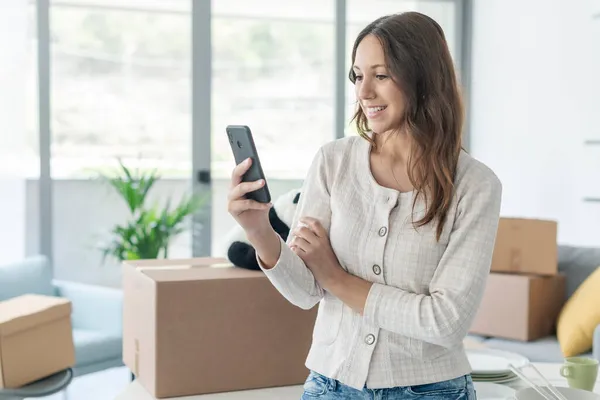 Donna Felice Connettersi Con Suo Smartphone Nella Sua Nuova Casa — Foto Stock