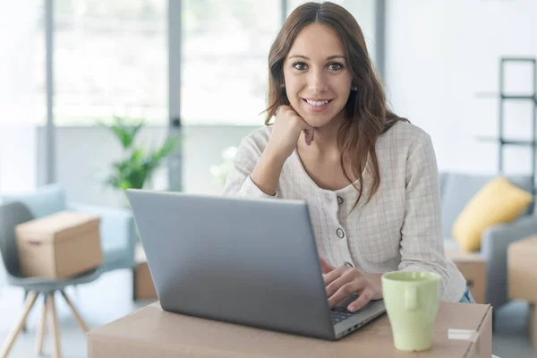 Glimlachende Vrouw Verhuizen Haar Nieuwe Huis Verbonden Met Haar Laptop — Stockfoto