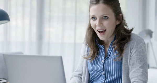 快乐的年轻女性与她的笔记本电脑连接和聊天 她读到这些信息 感到很惊讶 — 图库照片
