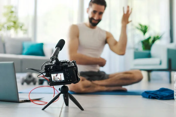 职业Vlogger为他的追随者录制了一段运动视频 他坐在瑜伽垫上解释练习 — 图库照片