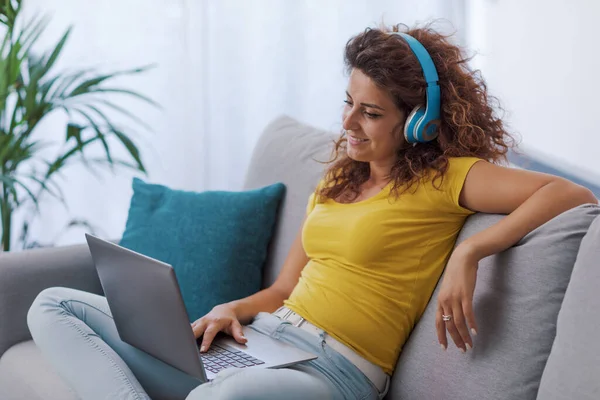 Vrouw Zit Bank Kijkt Films Laptop Draagt Een Koptelefoon — Stockfoto