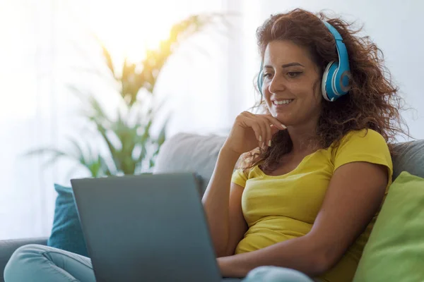 Kvinnan Sitter Soffan Och Tittar Filmer Laptopen Hon Bär Hörlurar — Stockfoto