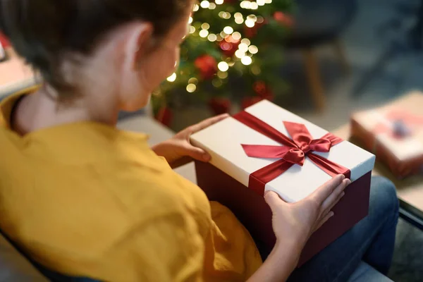 Frau Sitzt Auf Der Couch Und Hält Ein Weihnachtsgeschenk Der — Stockfoto