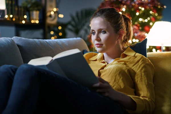 Lykkelig Kvinne Som Slapper Sofaen Hjemme Leser Bok Jula – stockfoto