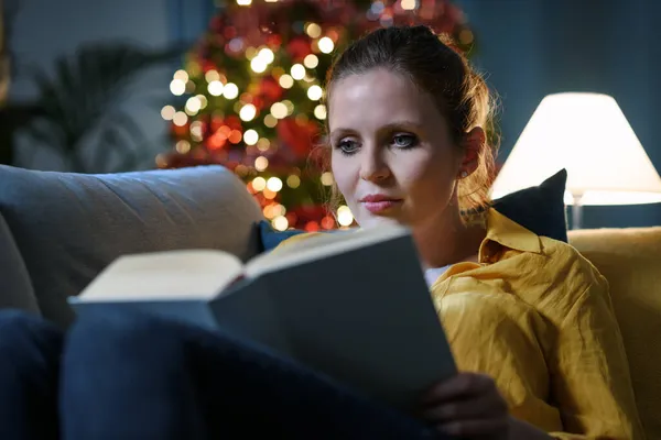 Happy Young Woman Lying Sofa Home Reading Book Christmas Holidays — Stock Photo, Image