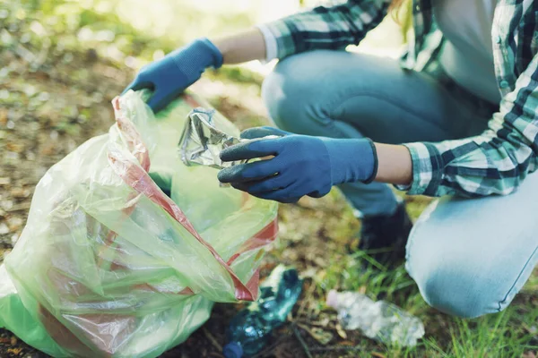 Cleanup volunteer collecting trash in the forest and holding a garbage bag, environmental protection concept