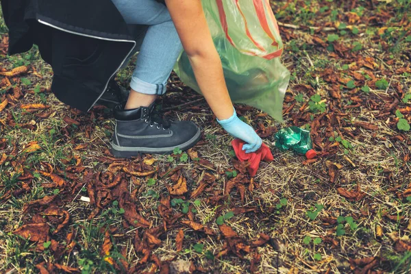 森の中でプラスチックや廃棄物を集める若い女性 — ストック写真