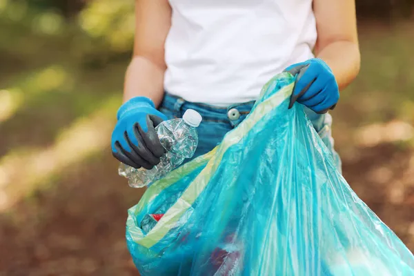 stock image Cleanup volunteer holding a garbage bag and collecting trash in the forest