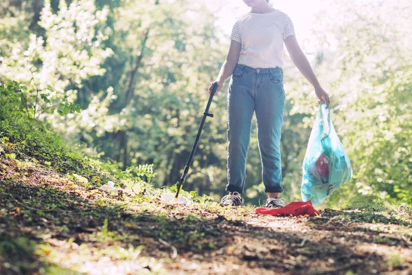 森を掃除する少女ゴミを集めてゴミ袋を持ってる環境保護の概念 — ストック写真