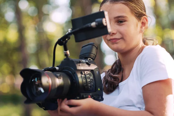 かわいいです女の子は森の中を歩くと プロのビデオカメラを使用してビデオを撮影 — ストック写真