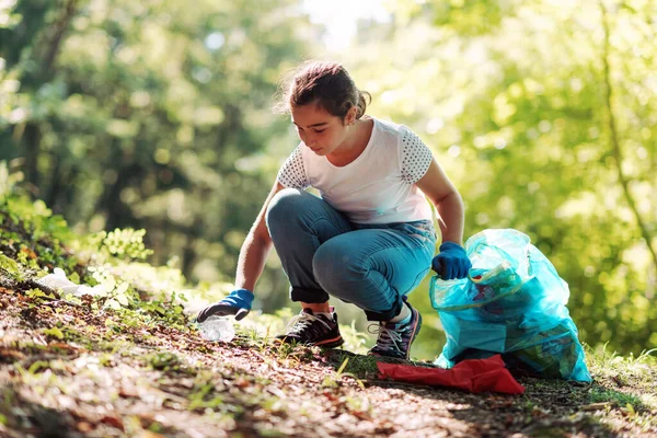 森を掃除する少女ゴミを集めてゴミ袋を持ってる環境保護の概念 — ストック写真