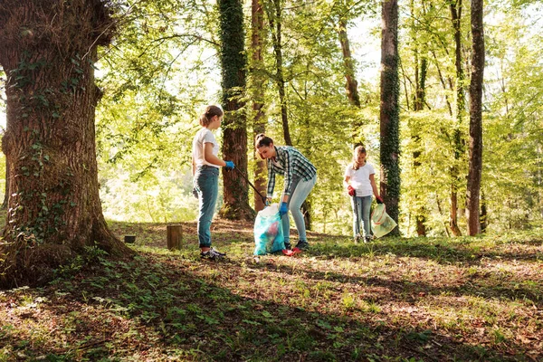 Młodzi Ochotnicy Razem Sprzątają Las Zbierają Śmieci Trzymają Worki Śmieci — Zdjęcie stockowe