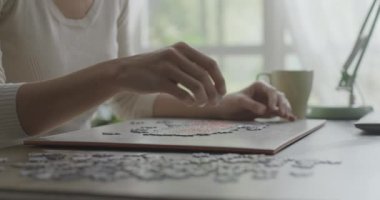 Evde bulmaca çözen bir kadın.
