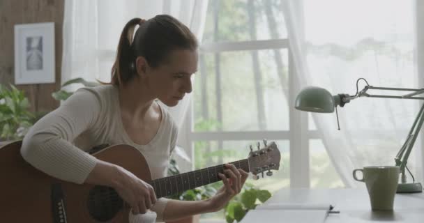 Mulher tocando guitarra em casa e compondo música — Vídeo de Stock