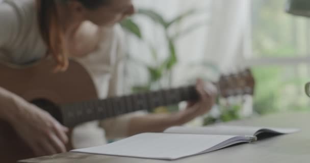 Donna che suona la chitarra a casa e compone musica — Video Stock