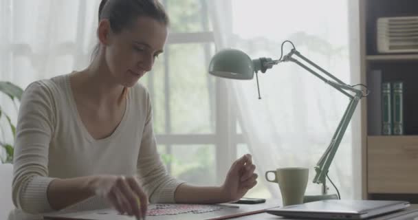 Woman solving a puzzle at home — Stock Video