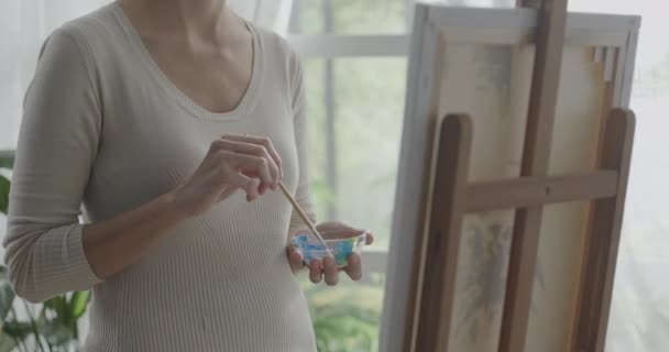 Vrouw schilderend op doek in haar atelier — Stockvideo
