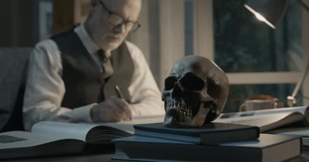 Academic professor studying a human skull — Stock Video
