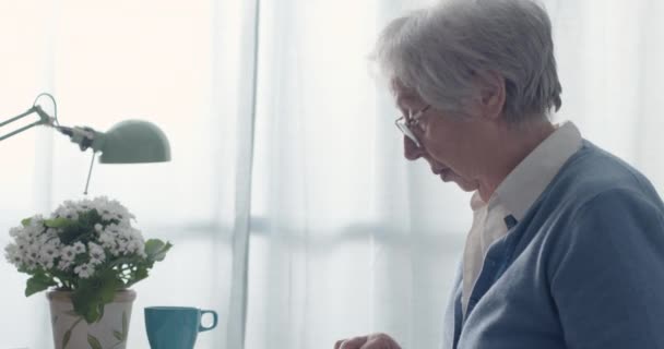 Ηλικιωμένη γυναίκα παίζει παζλ στο σπίτι — Αρχείο Βίντεο