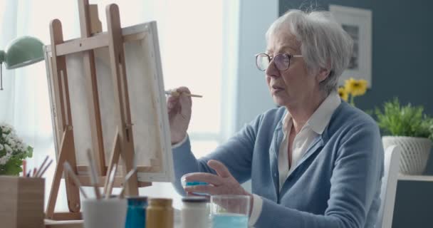 Creative senior woman painting on canvas — Stock Video
