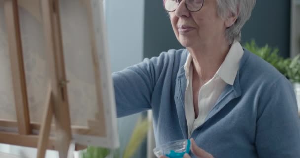 Творческая живопись пожилых женщин на холсте — стоковое видео