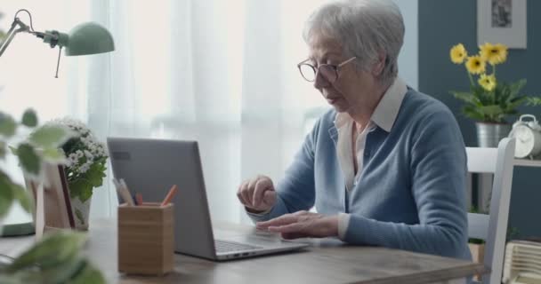Starszy kobieta za pomocą laptopa w domu — Wideo stockowe