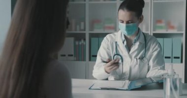 Doktor hastanın tıbbi kayıtlarını kontrol ediyor.