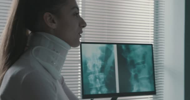 Arzt berät Patientin mit Halswirbelsäule — Stockvideo
