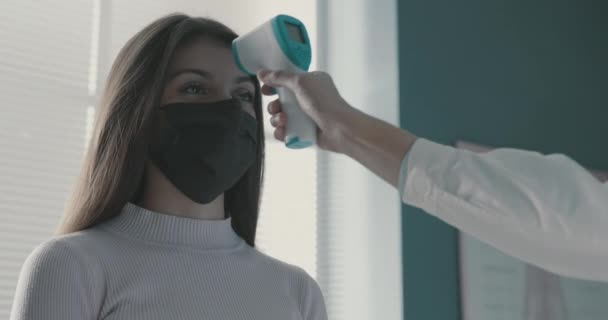 Arzt misst die Körpertemperatur einer Frau — Stockvideo