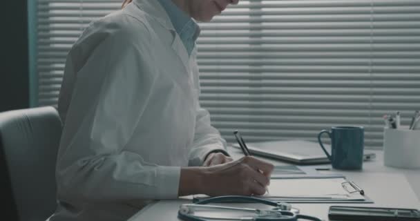 Läkare som skriver ut ett recept till en äldre patient — Stockvideo