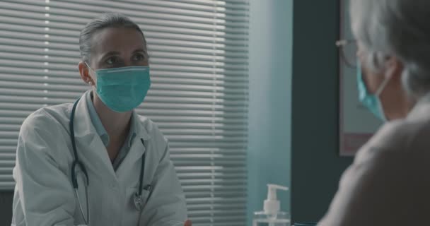 Médecin et patient âgé parlant ensemble dans le bureau — Video