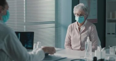 Kıdemli hasta ve doktor birlikte konuşuyorlar.