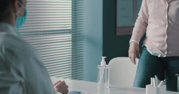 Старший пациент дезинфицирует руки в кабинете врача — стоковое видео